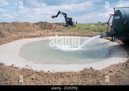 Artenschutz, Traktor mit Wassertank füllt neu geschaffenes Laichwasser für Amphibien in Kulturlandschaften, Stolberg, Nord Stockfoto