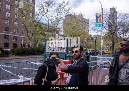 NEW YORK, NEW YORK - 24. APRIL: Die Leute posieren für Selfie mit Free Palestine Graffiti vor der Columbia University am 24. April 2024 in New York City. Der Sprecher des Repräsentantenhauses Mike Johnson besuchte den Campus, als Schulverwalter und pro-palästinensische Schülerprotestierende Fortschritte bei den Verhandlungen machten, nachdem die Schule eine Mitternachtsfrist für die Auflösung des Lagers festgelegt hatte und eine Verlängerung um 48 Stunden vereinbart hatte. Johnson hat den Rücktritt des Präsidenten der Columbia University Minouche Shafik gefordert. Stockfoto