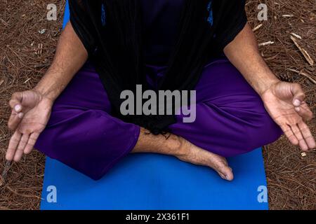 Vorderansicht eines nicht erkennbaren jungen lateinamerikanischen Mannes in Meditationsposition im Freien. Meditation und Yoga. Stockfoto