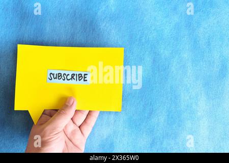 Menschliche Hand hält Sprechblase mit geschriebenem Wort jetzt abonnieren. Stockfoto