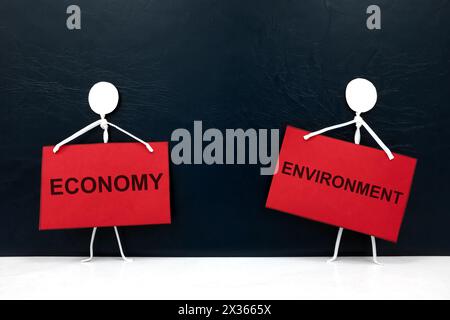 Wirtschaftlichkeit versus Umweltkonzept. Menschliche Hand nimmt Holzblock auf. Stockfoto