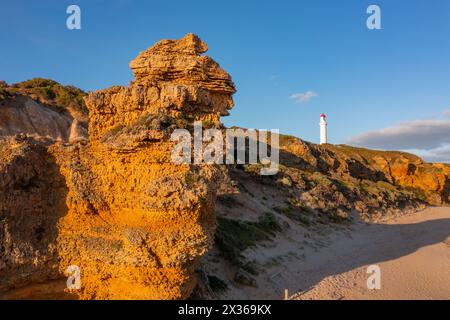 Blick aus der Ferne auf einen weißen Leuchtturm auf erodierten Klippen über einer zerklüfteten Küste am Aireys Inlet an der Great Ocean Road in Victoria, Australien Stockfoto