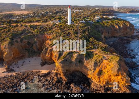 Blick aus der Ferne auf einen weißen Leuchtturm auf erodierten Klippen über einer zerklüfteten Küste am Aireys Inlet an der Great Ocean Road in Victoria, Australien Stockfoto