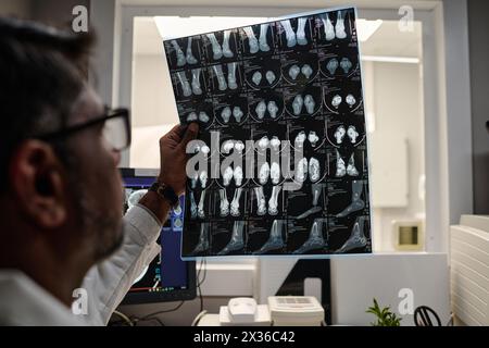 Selektive Fokusnaht eines birazialen männlichen Radiographen, der mit dem Kopf-CT-Röntgenbild arbeitet Stockfoto