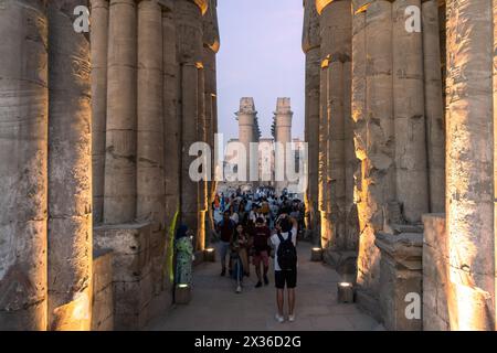 Luxor, Ägypten - 25. November 2023: Touristen besuchen den berühmten Luxor-Tempel in Ägypten mit der beeindruckenden Großen Kolonnadenhalle in der Abenddämmerung Stockfoto