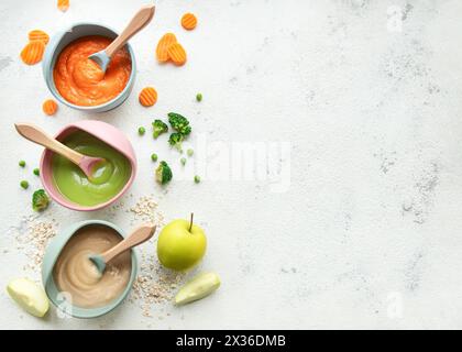 Gesunde Babynahrung in Schüsseln. Verschiedene Schüsseln mit Obst- und Gemüsepüree, Blick von oben Stockfoto