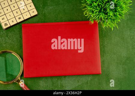 Eine Lupe, ein Taschenrechner und ein geschlossenes Notizbuch mit einem großen Geheimnis auf grüner Oberfläche. Geheimnisvolle Atmosphäre. Ein Ort zum Kopieren Stockfoto