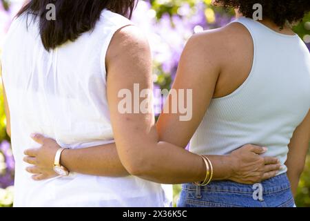 Reife birassische Frau und junge birassische Frau, die sich zu Hause im Garten umarmen Stockfoto