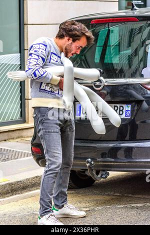 Junger Mann (Ladenbesitzer), der Schwierigkeiten hat, vier Puppenpuppen in sein Auto zu laden - Tours, Indre-et-Loire (37), Frankreich. Stockfoto