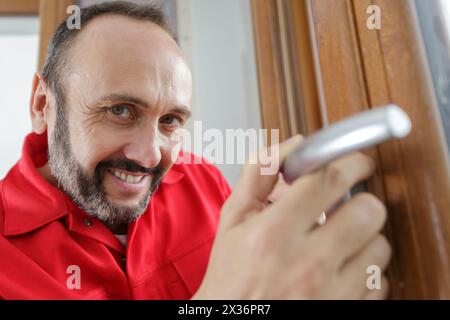 Nahaufnahme des Handwerkers, der am Türgriff arbeitet Stockfoto