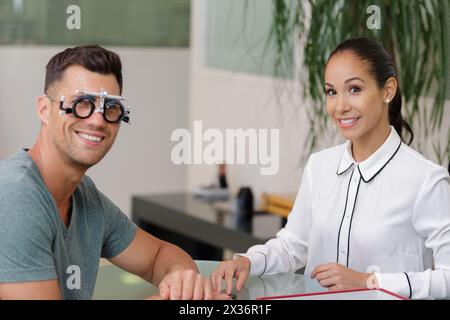Augenärztin mit männlichem Patienten mit Testbrille Stockfoto