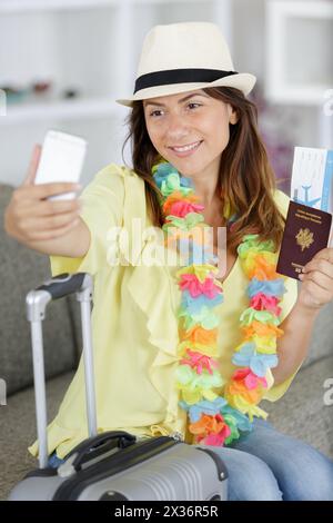 Frau zu Hause, die einen Reisepass hält, um Selfie zu machen Stockfoto