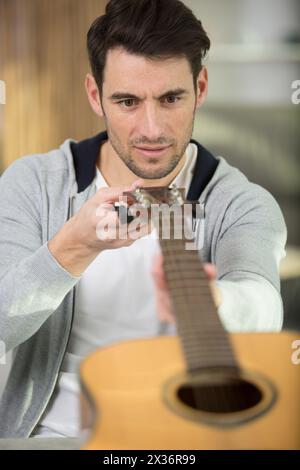 Mann Gitarrist überprüft Gitarre Musikinstrument Stockfoto