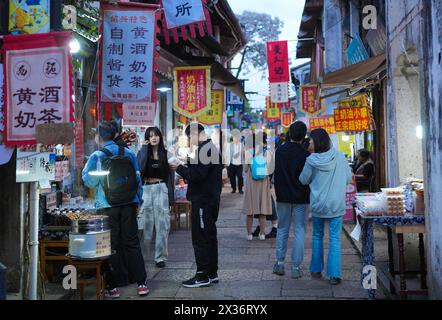 (240425) -- SHAOXING, 25. April 2024 (Xinhua) -- Touristen werden in der Cangqiao Straight Street in Shaoxing, ostchinesischer Provinz Zhejiang, 24. April 2024, fotografiert. Cangqiao Zhijie, wörtlich übersetzt als „Cangqiao Straight Street“, ist eine historische und kulturelle Stätte mit alten Häusern von einzigartigem Stil. Auf einer Fläche von 0,064 Quadratkilometern konnte die 1.500 Meter lange Straße bis in die Song-Dynastie (960–1279) zurückverfolgt werden. Seit den 1990er Jahren werden hier Sanierungs- und Schutzmaßnahmen durchgeführt Offiziell von der UNESCO als Cangqiao Historical Street bezeichnet, wurde diese Stätte mit dem Merit Award ausgezeichnet Stockfoto