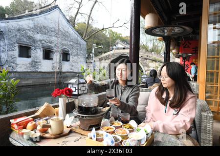 (240425) -- SHAOXING, 25. April 2024 (Xinhua) -- Menschen genießen ihre Freizeit in einem Geschäftsbetrieb in der Cangqiao Straight Street in Shaoxing, ostchinesischer Provinz Zhejiang, 13. März 2024. Cangqiao Zhijie, wörtlich übersetzt als „Cangqiao Straight Street“, ist eine historische und kulturelle Stätte mit alten Häusern von einzigartigem Stil. Auf einer Fläche von 0,064 Quadratkilometern konnte die 1.500 Meter lange Straße bis in die Song-Dynastie (960–1279) zurückverfolgt werden. Seit den 1990er Jahren werden hier Sanierungs- und Schutzmaßnahmen durchgeführt Von der UNESCO offiziell als Cangqiao Historical Street bezeichnet, Stockfoto