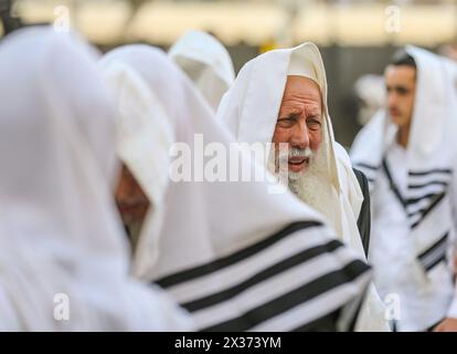 Jerusalem, Israel. April 2024. Ein jüdischer Mann, der mit einem Tallit bedeckt ist, steht unter anderem und betet sehr emotional bei The Wailing Wall Credit: Yoram Biberman/Alamy Live News. Stockfoto