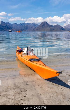 Leuchtend orange Meer Kajak Elgol mit und am Strand Meer Loch Scavaig Black Cuillin Berge im Hintergrund, Isle Of Skye, Schottland Stockfoto