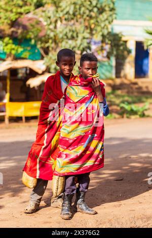 DEMEBECHA, ÄTHIOPIEN, 20. APRIL 2019. Äthiopische Straße am Morgen, lokale Teenager mit einer Decke bedeckt, um die Kälte draußen zu halten. Demebecha, Amhara Re Stockfoto