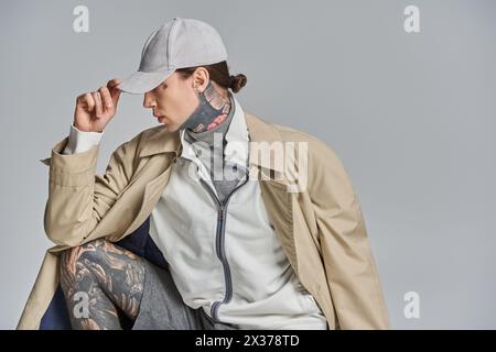 Eine Frau mit Tattoos sitzt elegant und strahlt Selbstvertrauen und Individualität aus. Stockfoto