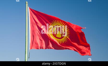 Die Fahne von Kirgisistan, Kirgisien, flattert im Wind, isoliert gegen blauer Himmel Stockfoto