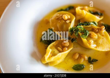 Nahaufnahme von hausgemachten Stachelpilzen Ravioli mit Spinat. Ravioli mit Pilzen in einer cremigen Sauce. Restaurantgericht. Stockfoto