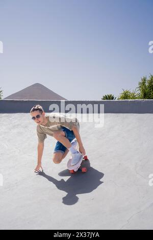 Ein junger Mann, der geschickt die Rampe auf einem Surfskate herunterfährt und seine Balance und Kontrolle über das Board unter Beweis stellt. Stockfoto