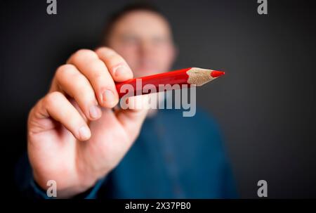 Die Spitze des roten Bleistifts zeigt auf die Kamera und auf Sie. Abstimmungsstift mit roter Schreibfarbe. Stimme ab. Konzentrieren Sie sich auf den scharfen roten poi Stockfoto
