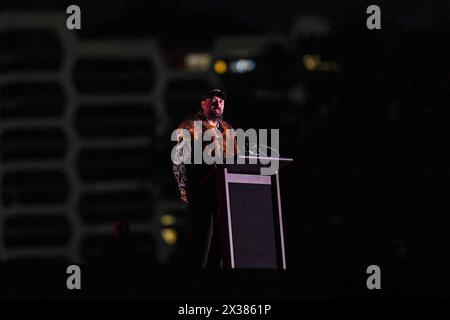 Der ältere Onkel der australischen Ureinwohner Mark Brown von Bunurong eröffnet den ANZAC Day Dawn Service am Melbourne Shrine of Remembrance Memorial mit „Welcome to the Country“. Der Dawn Service wird als Teil der ANZAC Day Zeremonien durchgeführt, um diejenigen zu ehren, die in der Schlacht gefallen sind. Während des Ersten Weltkriegs wurde die Dämmerung zu einer bevorzugten Zeit für Angriffe. Soldaten in Verteidigungspositionen wurden vor Sonnenaufgang im Dunkeln geweckt und bemannten ihre Waffen vor dem ersten Licht. Nach dem Ersten Weltkrieg suchten zurückgekehrte Soldaten die Kameradschaft, die sie in den ruhigen, friedlichen Momenten vor Sonnenaufgang fühlten. Ich erinnere mich an die Momente in daw Stockfoto