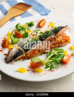 Im Ofen gekochte Makrele gefüllt mit Tomatensauce und Gemüse. Stockfoto