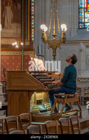 Paris, Frankreich - 04 12 2024: Basilika Saint Clotilde. Blick in die Basilika Sacré-Coeur mit einem Musiker, der die Orgel spielt Stockfoto