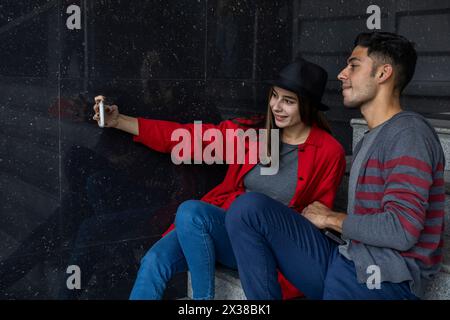 Zwei junge lateinamerikanische Brüder teilen sich etwas Zeit und machen ein Selbstporträt. Technologiekonzept. Stockfoto