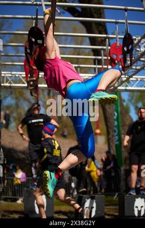 Ukrainische Frau, die am 20. April 2024 beim Spartan-Rennen in Kiew an Bars mit Ringschaukeln trainiert Stockfoto