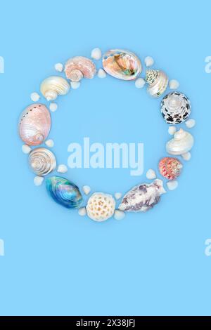 Perlmutt und natürliche Muschelkranzdekoration auf blauem Hintergrund. Sommer-Kunstdesign am Meer für Logo oder Grußkarte. Stockfoto