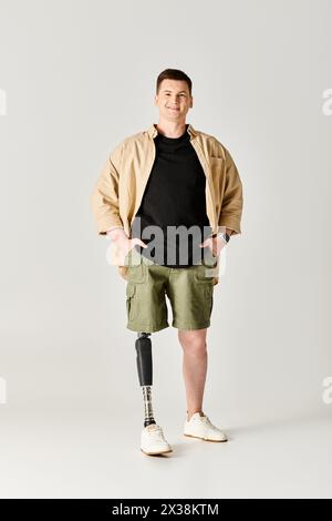 Gutaussehender Mann mit Beinprothese, der selbstbewusst mit Händen auf Hüften steht. Stockfoto