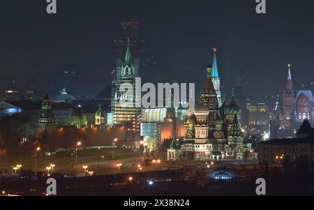 Kreml-Mauer, Spassky-Turm wird restauriert, Wassilevski-Abfahrt und Basilius-Kathedrale in Moskau, Russland bei Nacht Stockfoto