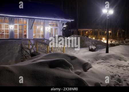 Beleuchtete einstöckige Häuser in der Winternacht. Stockfoto