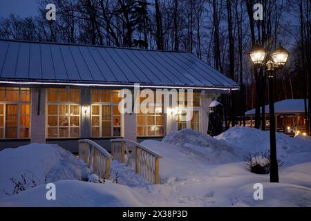 VASILYEVSKOYE, REGION MOSKAU, RUSSLAND - 4. Februar 2017: Einstöckige beleuchtete Häuser und Laterne am Winterabend im Provence-Hotel Four Seasons. Stockfoto