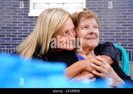 Mutter und Tochter umarmen sich draußen. Frauenfamilie Stockfoto