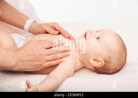 Drei Monate Babymädchen empfängt Brust Massage vom weiblichen Masseurin Stockfoto