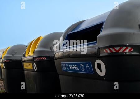 Die Hand einer Person, die einen Karton Eier in den Mülleimer wirft. Der Mülleimer ist blau und hat einen Deckel Stockfoto