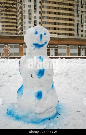 Schneemann in blauer Farbe im Innenhof des Wohngebäudes. Stockfoto