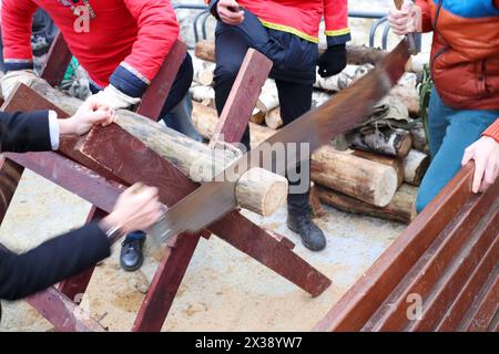 Hände von zwei Männern sägten Holz auf der nationalen Messe im Freien, Noface Stockfoto