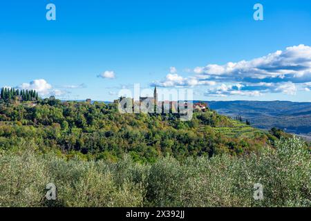 Groznjan Kroatien eine wunderschöne, auf einem Hügel gelegene Steinkirche in der Mitte und Hügel und Berge um sie herum. Stockfoto