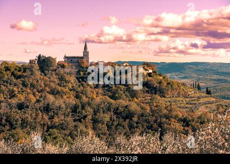 Groznjan Kroatien eine wunderschöne, auf einem Hügel gelegene Steinkirche in der Mitte und Hügel und Berge um sie herum. Stockfoto