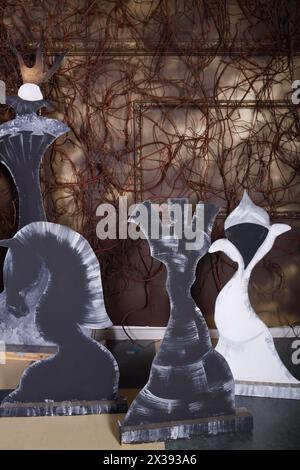 Braune Wand mit Baguette und vielen Zweigen, Schachfiguren aus Pappe im Studio Stockfoto