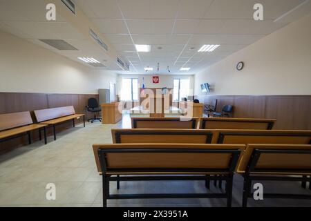 MOSKAU, RUSSLAND - 1. JUL 2015: Gerichtssaal mit Holzmöbeln, Flagge und Uhr an der Wand. Stockfoto