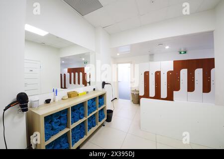 Viele Schließfächer für Kleidung, Regale mit Handtüchern im Zimmer im Fitnesscenter Stockfoto