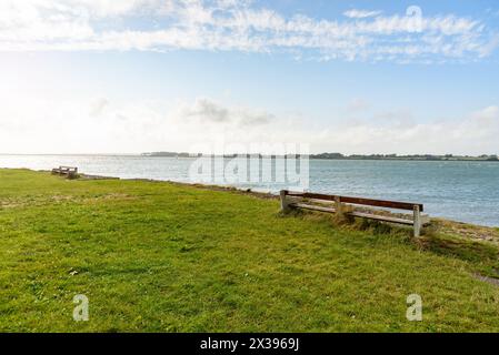 Leere Holzbänke mit Blick auf das Meer an einem klaren Sommertag Stockfoto