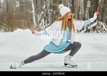 Junge Frau läuft auf der Eislaufbahn im Winterpark. Stockfoto