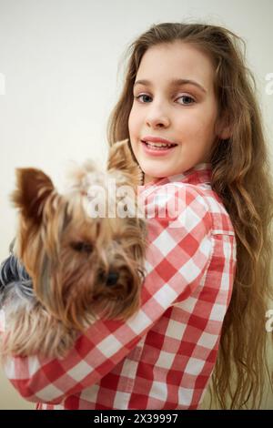 Porträt eines Mädchens mit yorkshire Terrier auf Armen. Stockfoto